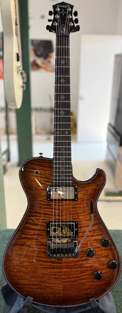 A brown sunburst electric guitar with a glossy finish and star inlays on the fretboard.