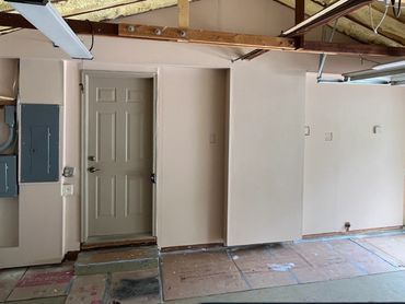 Enclosed open stud garage wall with fire code drywall and built soffit to hide garage wiring.