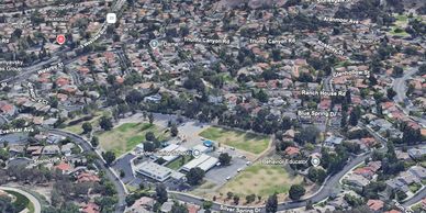 Aerial view of a suburban neighborhood with schools and labeled streets.