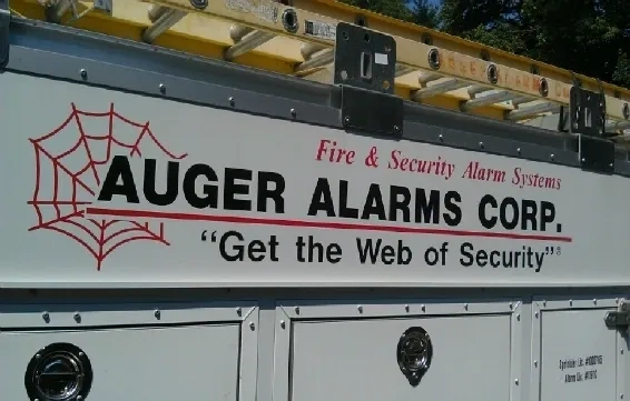 A close-up view of the side of a white service vehicle featuring a logo