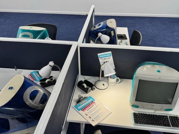 Four iMac G3 computers on desks