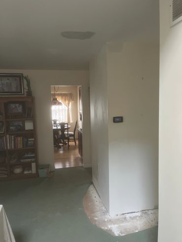 Room with carpet partially removed and a ceiling stain.