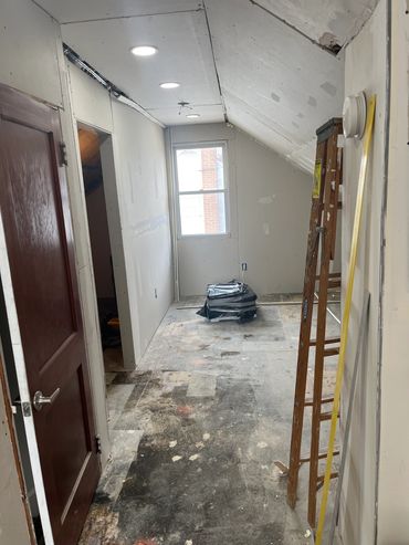 Room under renovation with drywall and exposed floor.