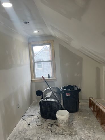 Room under construction with drywall and tools.