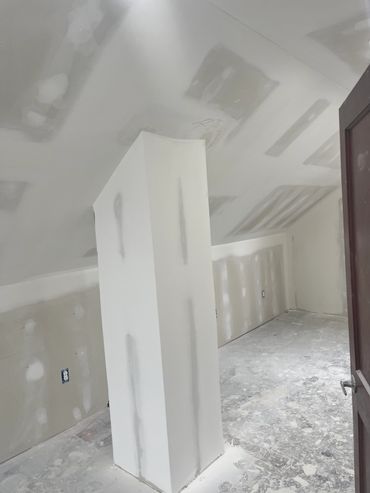 Interior room under construction with drywall.