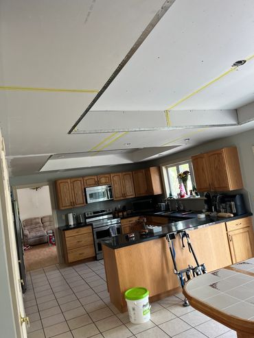 Kitchen under renovation with drywall ceiling.