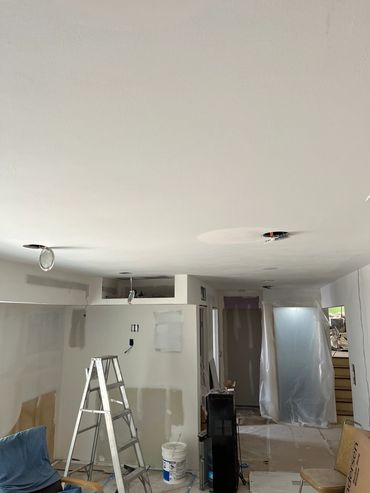 Room under renovation with ladder and covered area.