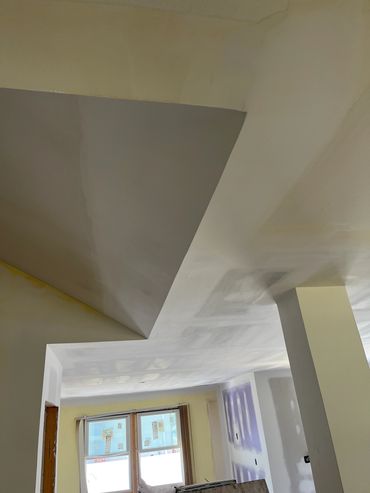 Indoor ceiling with geometric design and renovation work in progress.