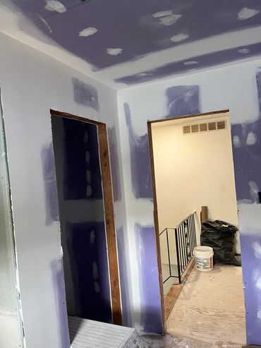 Room under construction with drywall installation.