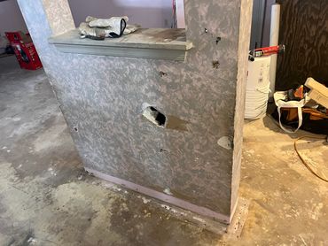 Partition wall under construction with work gloves on top.