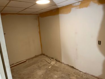 Room under renovation with bare walls and floor.