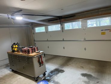 Garage with workbench and open garage door.