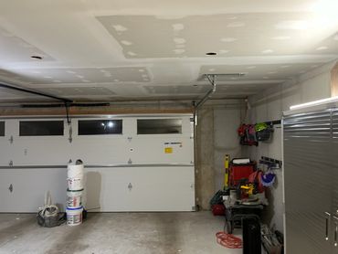 Garage with drywall repairs and tools.