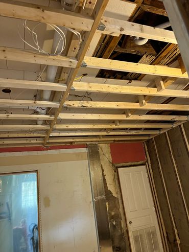 Exposed ceiling and wall framing in under-construction room.