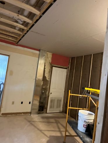 Room under renovation with drywall and insulation work.