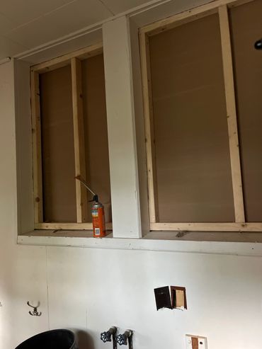 Two framed openings in a wall with a can of expanding foam.