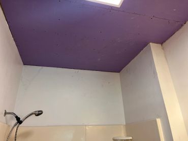 Purple ceiling in a bathroom under construction.