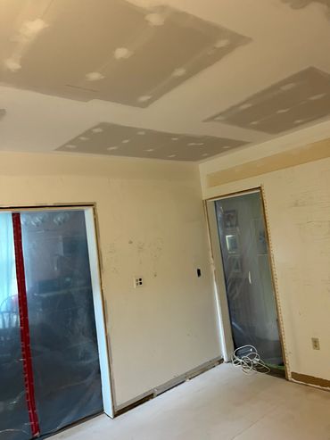 Room under renovation with drywall patches on ceiling.