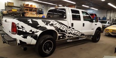 A white pick-up truck with a ragged black stripe design and the words "POWERSTROKE"