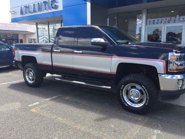 A pick-up truck wrapped in blue and gray vinyl wrap