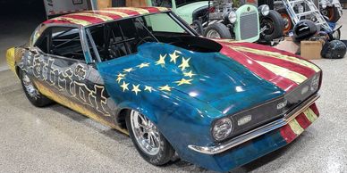 A car covered in US flag vinyl wrap and the words "Patriot" on the side