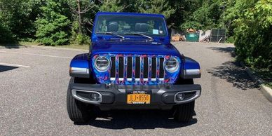 A blue jeep with custom grill skin