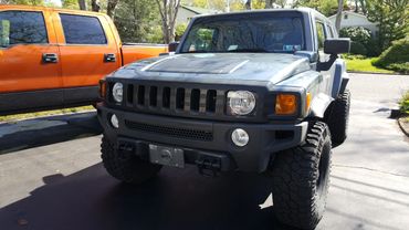 A black jeep with a stripe custom grill skin