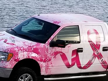 A pick-up truck with breast cancer awareness-themed wrap (slightly from above)