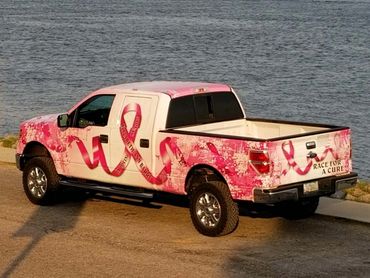 A pick-up truck with breast cancer awareness-themed wrap (side)