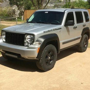 A gray jeep with black custom grill skin