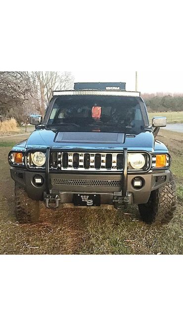 A blue jeep with a US flag custom grill skin