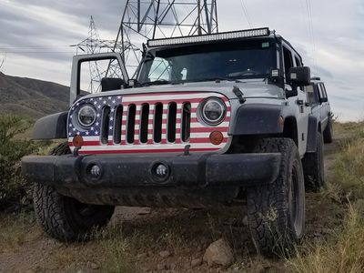A jeep with an American flag wrap on the front