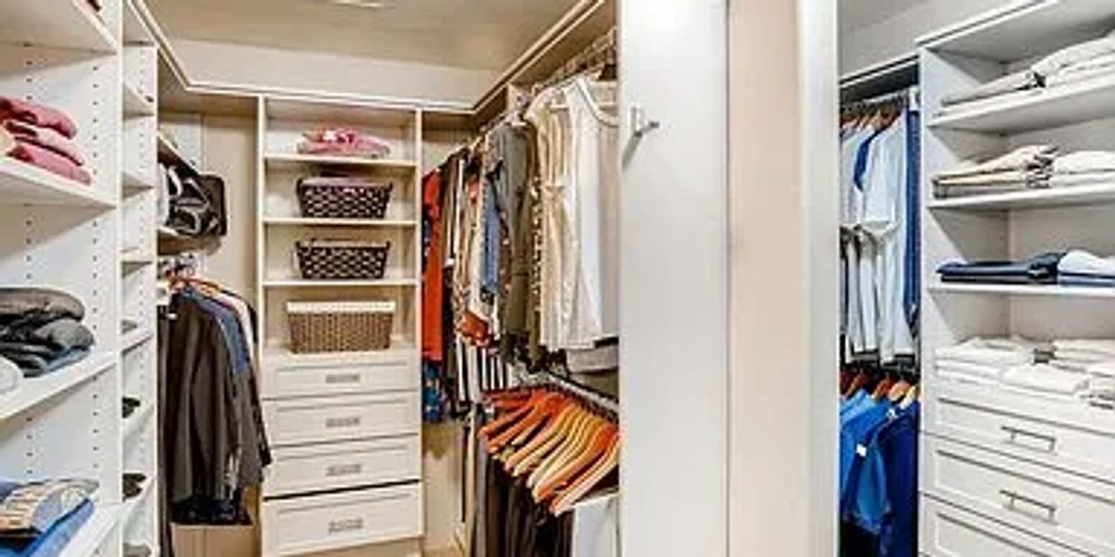 Picture of organized master bedroom closet. Bedroom closet organization.