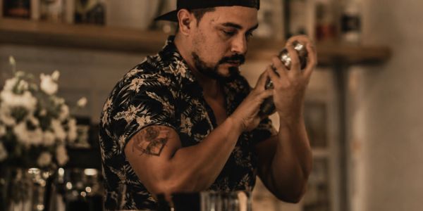 Man shaking a cocktail shaker in a bar.