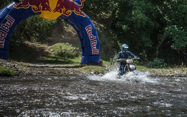 Husaberg FE350 Riding through a river across finish line at Redbull Romaniacs