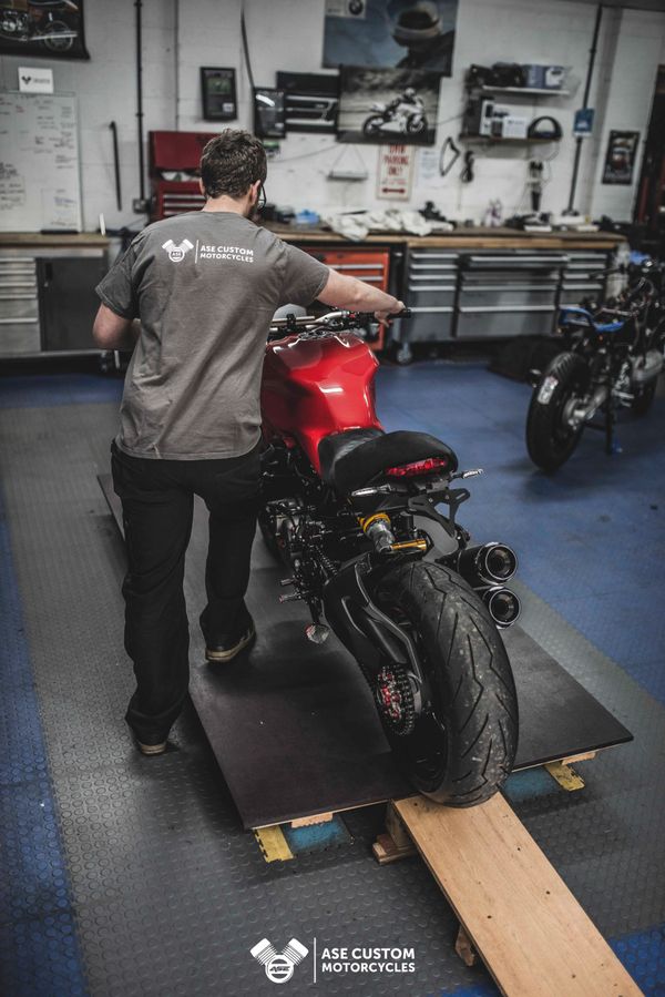 Pushing Ducati Monster 1200s onto a workshop ramp