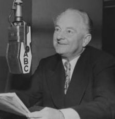 Science of Mind founder Ernest Holmes speaking into an ABC microphone in a radio studio.