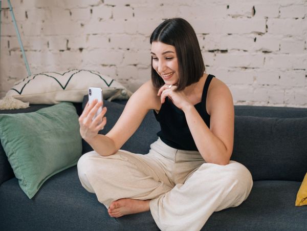Young woman taking a selfie on a sofa.