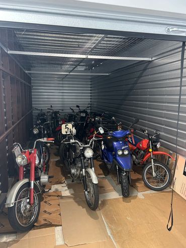 A collection of motorcycles stored in a metal garage.
