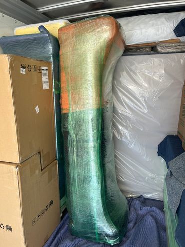 Wrapped furniture and cardboard boxes packed in a moving truck.