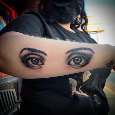 black and gray realism human eyes forearm tattoo