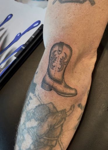 Black and gray cowboy boot tattoo