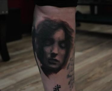 ethereal black and gray realism portrait tattoo of a woman with her eyes closed