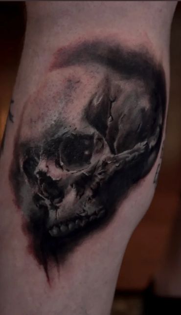 black and gray realism tattoo of a skull with smeared and dripping ink