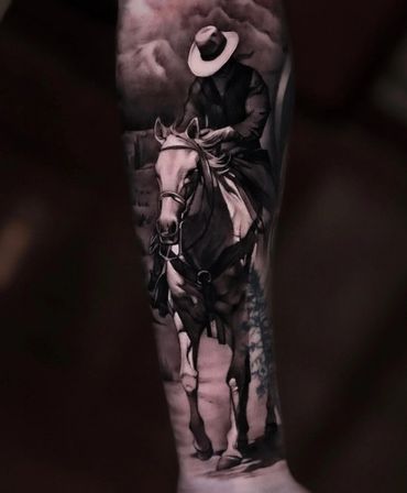 black and gray ultra realism cowboy on a horse tattoo