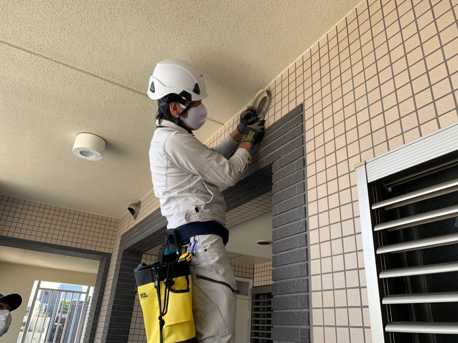 作業員が壁の上部で作業している。