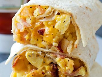 Bacon, Egg, Potato & Cheese breakfast burrito in a flour tortilla