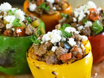 Colorful stuffed bell peppers with ground meat and cheese topping.
