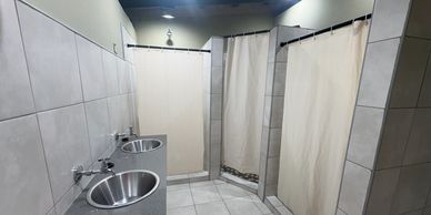 Newly constructed modern bathhouse has multiple showers, toiletsand sinks.