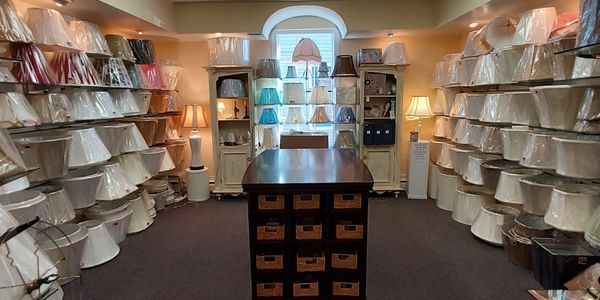 Room filled with various lamp shades neatly displayed on shelves.